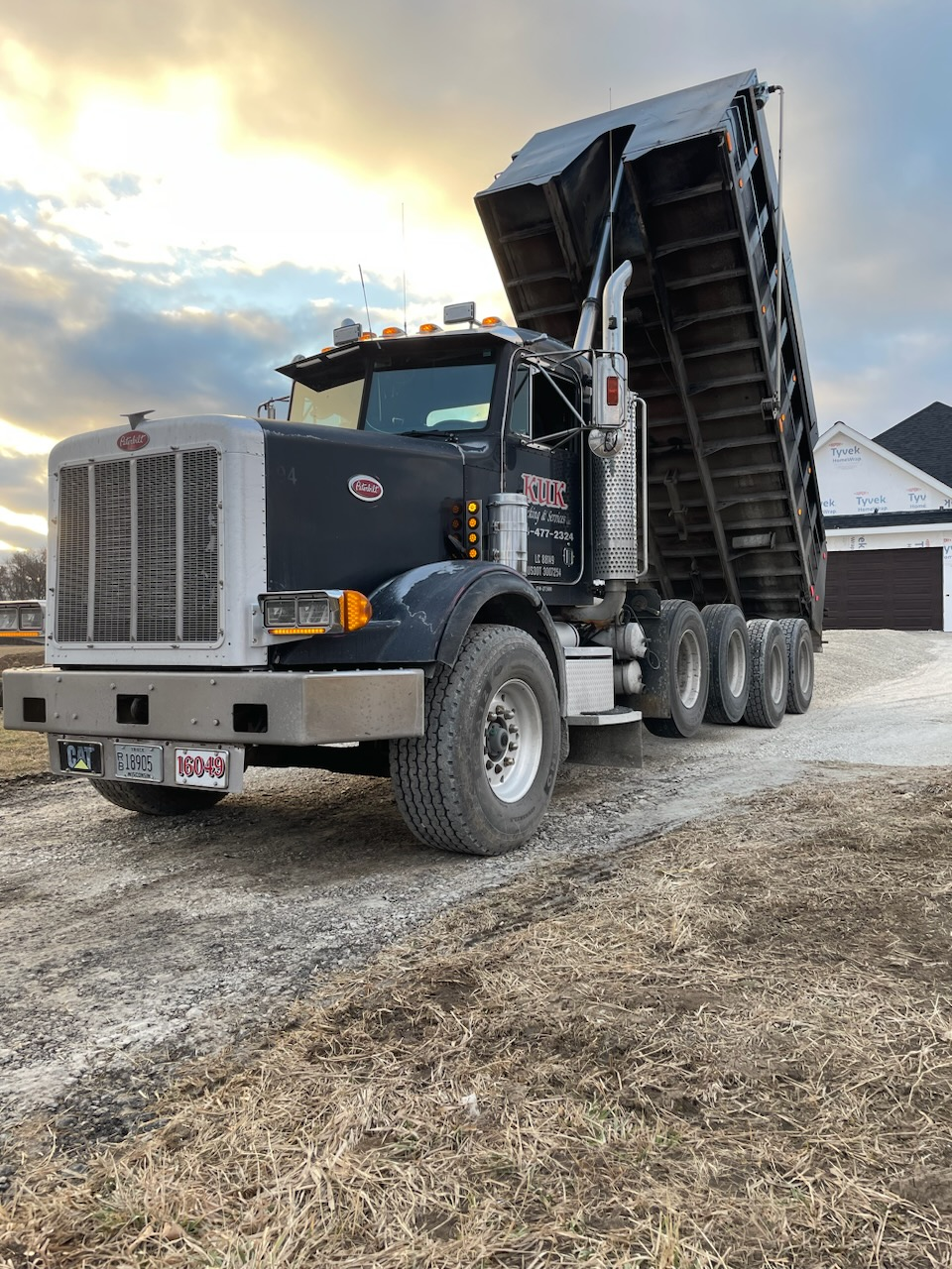 Excavator chained down on the Kuk Trucking lowboy trailer